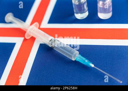 Pharmacologie et médecine islande concept. vaccin contre le coronavirus covid. Ampoules de vaccin, seringue sur fond de drapeau national. natio Banque D'Images