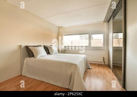 un lit dans une chambre avec parquet et draps blancs sur le cheveu Banque D'Images