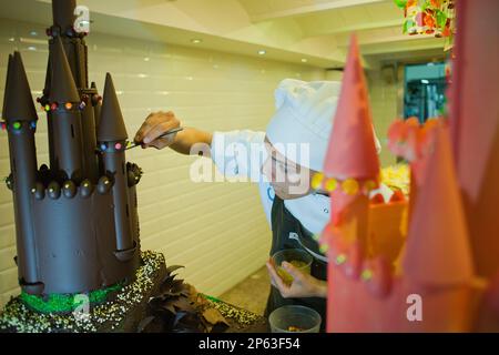 Baker faisant un Gâteau au chocolat typique du lundi de Pascua, le parrain donne son filleul, tradition catalane, Escribà boulangerie, 83 la Rambla, Barc Banque D'Images