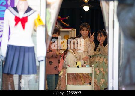 BUSAN, 7 mars 2023 (Xinhua) -- les touristes essaient des vêtements traditionnels dans un magasin de location de hanbok au village culturel de Gamcheon à Busan, Corée du Sud, 7 mars 2023. Situé sur les contreforts d'une montagne côtière à Busan, le Gamcheon Culture Village est célèbre pour ses maisons construites à la mode escalier et ses ruelles décorées de peintures murales et de sculptures. (Xinhua/Wang Yiliang) Banque D'Images