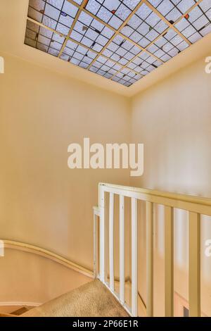 l'intérieur d'une chambre avec une lucarne au-dessus et des escaliers menant au deuxième étage d'un appartement Banque D'Images