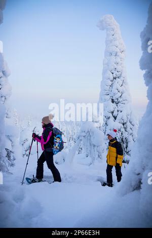 Mère gaie avec son raquette dans la forêt gelée, Parc national d'Oulanka, Ruka Kuusamo, Laponie, Finlande, Europe Banque D'Images