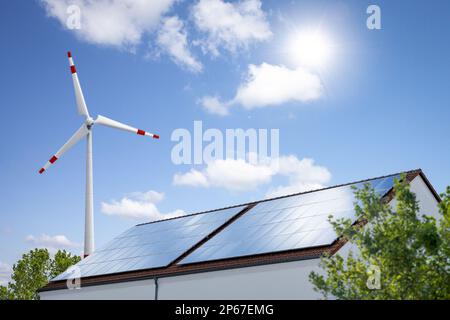 Panneaux solaires sur un toit et une éolienne pour la production d'énergie renouvelable Banque D'Images