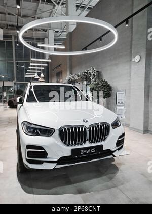 Nouvelle voiture allemande blanche BMW X5 avec nimbus dans une salle d'exposition de voiture, verticale Banque D'Images