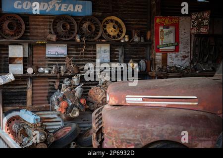 Ancien atelier de mécanicien de voitures abandonnées sur la route du désert. À l'intérieur se trouve un vieux pick-up F-1 de Ford. Banque D'Images