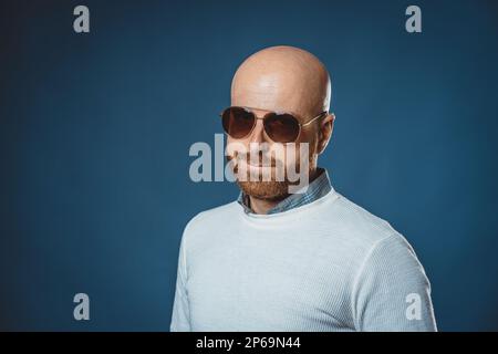 Photo d'un type caucasien gentil avec la barbe, le soleil glamp et le fond bleu Banque D'Images