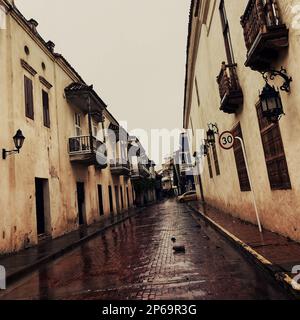 Une rue coloniale dans la ville fortifiée est vue vide de touristes en raison d'une tempête de pluie prolongée pendant la saison des pluies annuelle à Cartagena, Colombie. Banque D'Images