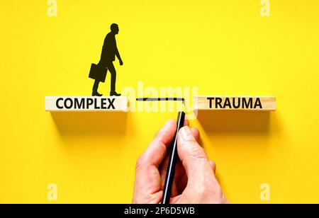 Symbole de traumatisme complexe. Concept mots trauma complexe sur bloc de bois. Beau tableau noir fond noir. Psychologie des affaires complexe traumatisme concep Banque D'Images