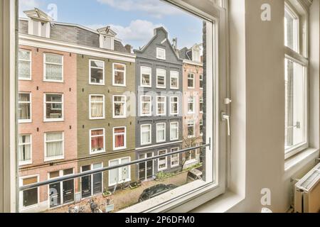 une vue extérieure d'une fenêtre dans un quartier résidentiel avec beaucoup de fenêtres et de petites maisons de l'autre côté Banque D'Images