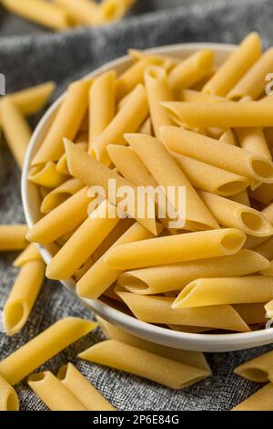 Pâtes Mostaccioli Penne Lisce crues sèches dans un bol Banque D'Images