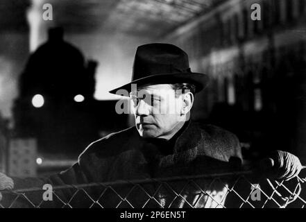 1949 : l'acteur Joseph COTTEN ( 1905 - 1994 ) dans un film pubblicavitaire pour LE TROISIÈME HOMME ( il terzo uomo ) par Carol Reed , D'un roman de Graham Greene - FILM NOIR - CINÉMA - ATTORE CINEMATOGRAFICO - chapeau - cappello - cappoto - manteau - FILM - TILLER - SUSPANCE - train - treno - stazione ferroviaria - gare ferroviaire ---- Archivio GBB Archivio Banque D'Images