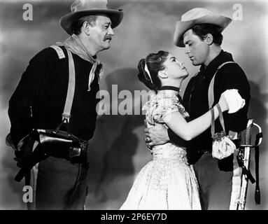 1948 : les célèbres acteurs de cinéma JOHN WAYNE avec JOANNE DRU dans un film pubblicavitaire tourné pour le film QU'ELLE PORTAIT Un RUBAN JAUNE ( I cavalieri del Nord-Ovest ) par John FORD , D'un roman de James Warner Bellah - CINÉMA - ATTORE CINEMATOGRAFICO - COW-BOY - WESTERN - guanti - gants - FILM - Foulard - bandanna - bandana - uniforme militaire - uniforme divisa militare - cavalleria - profilo - profil - duo - coppia - innamorati - amanti - Amoureux - boccoli - boucles - spada - épée - bretelle - cappello - chapeau - étreinte - abbraccio - TRIO --- Archivio GBB Banque D'Images