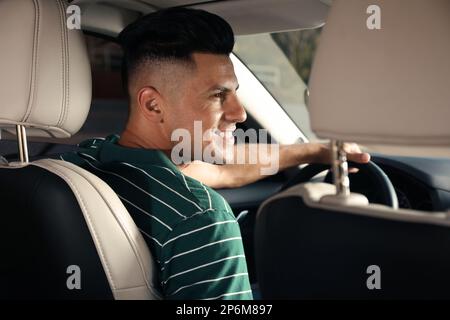 Beau chauffeur de taxi assis dans une voiture moderne Banque D'Images