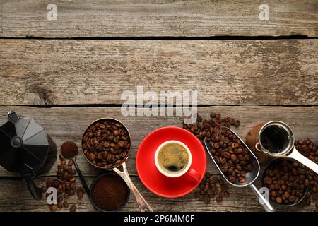 Cafetière, haricots, poudre et tasse de boisson sur table en bois, plat. Espace pour le texte Banque D'Images