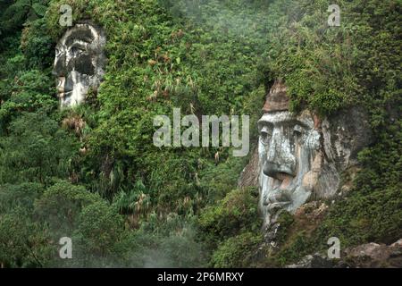 Visages géants illustrant les personnages de Toar et Lumimuut, les ancêtres du peuple minahasan selon la mythologie locale, qui sont construits sur le flanc d'une colline à Bukit Kasih, une destination populaire pour le tourisme culturel, naturel, et religieux situé dans le village de Kanonang, West Kawangkoan, Minahasa, North Sulawesi, Indonésie. Banque D'Images