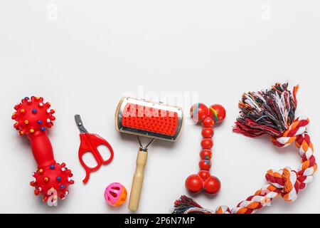 Jeu de jouets pour animaux de compagnie, brosse de toilettage et coupe-ongles sur fond clair Banque D'Images