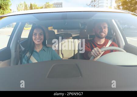 Jeune femme et conducteur dans une voiture moderne, vue par le pare-brise Banque D'Images