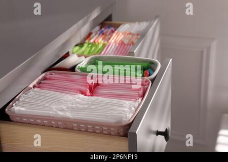 Ouvrez les tiroirs de l'armoire avec les tapis menstruels, les tampons et les pantyliners à l'intérieur, en gros plan Banque D'Images