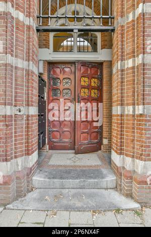 Amsterdam, pays-Bas - 10 avril 2021 : un bâtiment en brique avec une porte rouge au milieu et une fenêtre voûtée au sommet des portes Banque D'Images