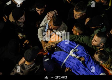 Jénine, Palestine, 07/03/2023, (NOTE DE LA RÉDACTION : l'image dépeint la mort) les Palestiniens portent le corps de l'un des six Palestiniens qui ont été tués par des balles de l'armée israélienne lors d'un raid sur le camp occupé de Djénine en Cisjordanie. De grandes forces de l'armée israélienne ont pris d'assaut le camp de Jénine et ont détruit un abri dans lequel 6 Palestiniens armés ont été renfermées, y compris l'Abdel-Fattah Khrusheh palestinien, qui a mené l'attaque de tir sur un colon israélien de sa ville, Hawara, sur 28 février. Le Ministère palestinien de la santé a déclaré que 6 Palestiniens avaient été tués au cours de ce raid. Banque D'Images