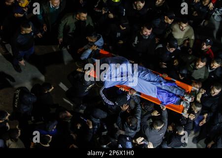 Jénine, Palestine, 07/03/2023, (NOTE DE LA RÉDACTION : l'image dépeint la mort) les Palestiniens portent le corps de l'un des six Palestiniens qui ont été tués par des balles de l'armée israélienne lors d'un raid sur le camp occupé de Djénine en Cisjordanie. De grandes forces de l'armée israélienne ont pris d'assaut le camp de Jénine et ont détruit un abri dans lequel 6 Palestiniens armés ont été renfermées, y compris l'Abdel-Fattah Khrusheh palestinien, qui a mené l'attaque de tir sur un colon israélien de sa ville, Hawara, sur 28 février. Le Ministère palestinien de la santé a déclaré que 6 Palestiniens avaient été tués au cours de ce raid. Banque D'Images