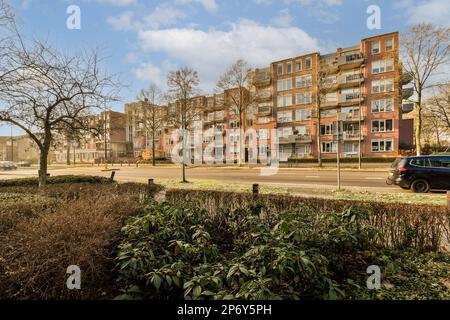 un complexe d'appartements avec des voitures garées dans la rue et des arbres à l'avant - vue sur les yeux est très, mais ce n'est pas le cas Banque D'Images