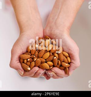 La solution santé de noisette. un bouquet d'amandes dans une personne a coupé les mains. Banque D'Images