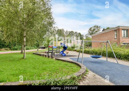 Amsterdam, pays-Bas - 10 avril 2021 : aire de jeux dans la cour arrière avec balançoire et aire de jeux pour enfants de l'autre côté du bâtiment Banque D'Images