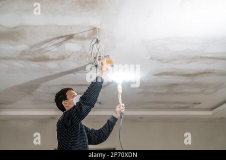 ponçage manuel du plafond en plaques de plâtre avec une truelle Banque D'Images