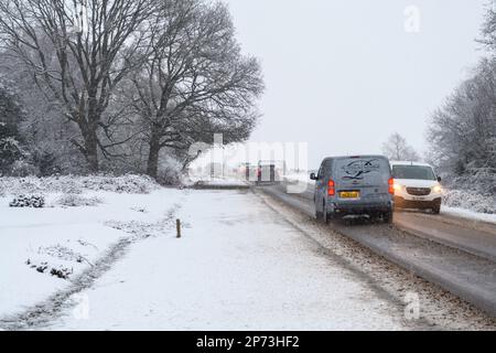 Trafic dans la neige, Godshill, New Forest, Hampshire, Angleterre, Royaume-Uni, 8 mars 2023, Météo : scènes hivernales après une chute de neige nocturne. Les températures avoisinent le point de congélation. Banque D'Images