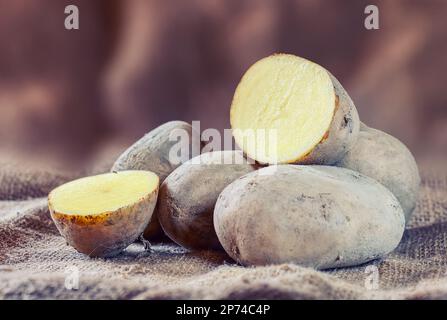 Nouvelles pommes de terre crues sur fond rustique. Banque D'Images