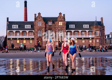 Des centaines de nageurs prennent un lever de soleil dans le Firth of Forth à Portobello Beach, Édimbourg, pour la Journée internationale des femmes. L'argent recueilli au cours de l'événement doit être donné à l'organisme de bienfaisance Women's Aid et cette année, c'est le 50th anniversaire de la succursale d'Édimbourg. Date de la photo: Mercredi 8 mars 2023. Banque D'Images