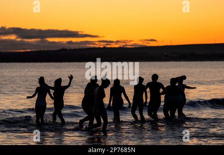 Des centaines de nageurs prennent un bain de soleil au Firth of Forth à Portobello Beach, Édimbourg, pour la Journée internationale de la femme. L'argent recueilli au cours de l'événement doit être donné à l'organisme de bienfaisance Women's Aid et cette année, c'est le 50th anniversaire de la succursale d'Édimbourg. Date de la photo: Mercredi 8 mars 2023. Banque D'Images