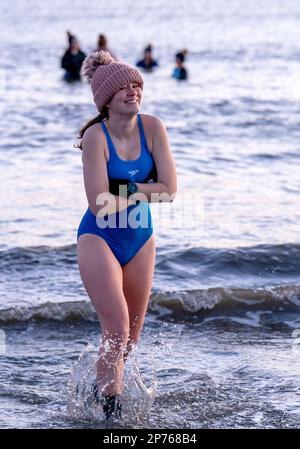 Des centaines de nageurs prennent un bain de soleil au Firth of Forth à Portobello Beach, Édimbourg, pour la Journée internationale de la femme. L'argent recueilli au cours de l'événement doit être donné à l'organisme de bienfaisance Women's Aid et cette année, c'est le 50th anniversaire de la succursale d'Édimbourg. Date de la photo: Mercredi 8 mars 2023. Banque D'Images