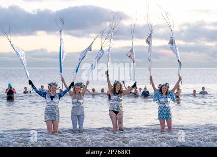 Des centaines de nageurs prennent un lever de soleil dans le Firth of Forth à Portobello Beach, Édimbourg, pour la Journée internationale des femmes. L'argent recueilli au cours de l'événement doit être donné à l'organisme de bienfaisance Women's Aid et cette année, c'est le 50th anniversaire de la succursale d'Édimbourg. Date de la photo: Mercredi 8 mars 2023. Banque D'Images