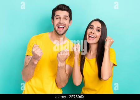 Photo d'un couple attrayant optimiste positif et optimiste surjoyé qui fait la fête des champions finalistes isolés sur fond de couleur bleu-vert Banque D'Images