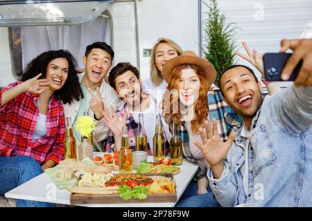 Amis de course mixtes prenant selfie sur téléphone mobile, fête en plein air sur arrière-plan de bande-annonce de voyage. Reposez-vous en dehors de la ville. Les gens heureux aiment. Week-ends dans Banque D'Images