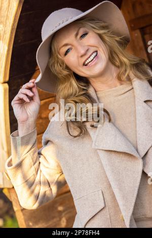 Attrayante heureuse souriante élégante femme d'âge moyen dehors portant un chapeau Banque D'Images