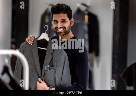 Jeune homme magasiner dans un magasin de vêtements Banque D'Images