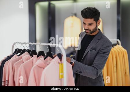 Jeune homme magasiner dans un magasin de vêtements Banque D'Images