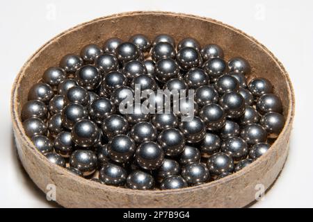 Pile de roulement à billes en métal neuf dans une boîte en carton. Gros plan en studio, isolé sur blanc. Banque D'Images