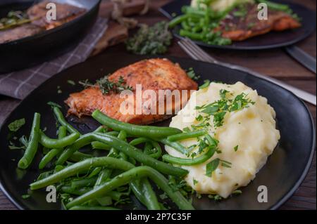 Haricots verts sur une assiette avec purée de pommes de terre et filet de saumon poêlé pour le dîner ou le repas du midi Banque D'Images