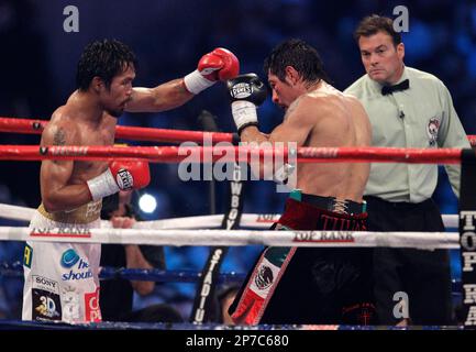 Manny Pacquiao, left, hits Antonio Margarito, right, during the 10th round of their WBC light middleweight title boxing match Saturday, Nov. 13, 2010, in Arlington, Texas. Pacquiao won by unanimous decesion. (AP Photo/LM Otero)
