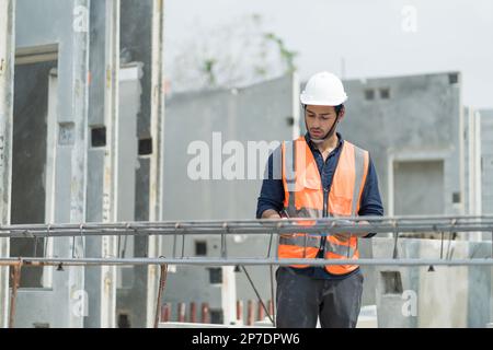 Les ingénieurs masculins inspectent et contrôlent le travail des employés et la qualité des produits manufacturés pour répondre aux normes de l'industrie Banque D'Images