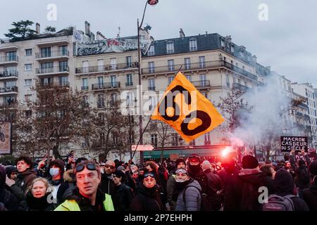 France / Paris / 07/03/2023, Jan Schmidt-Whitley/le Pictorium - manifestation contre la réforme des retraites à Paris - 7/3/2023 - France / Paris / Paris - Un manifestant porte un drapeau appelant à la retraite à 60. Même si le nombre de grévistes n'a pas atteint les records de janvier, les syndicats ont salué une « mobilisation historique » le mardi 7 mars, lors de manifestations qui ont rassemblé 1,28 millions de personnes en France, selon le ministère de l'intérieur, et 3,5 millions, selon la CGT. Banque D'Images