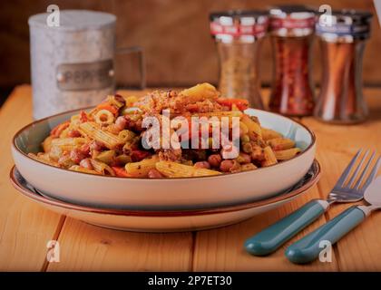 Des sardines et des pâtes saines avec des légumes et des haricots mélangés dans une sauce tomate. Banque D'Images