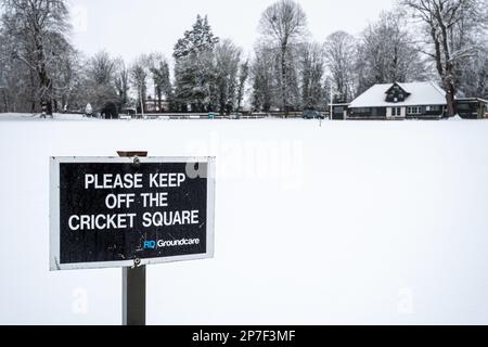 Terrain de cricket recouvert de neige avec lecture de panneaux Veuillez vous tenir à l'écart de Cricket Square, Farnham, Surrey, Angleterre, Royaume-Uni Banque D'Images