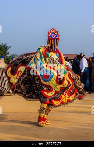 l'eguinguin aux couleurs vives invoque les esprits ancestraux dans une danse rituelle tourbillonnante au festival voodoo annuel ouidah au bénin Banque D'Images