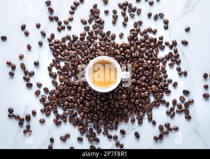 Tasse à espresso en pile de grains de café, gros plan Banque D'Images