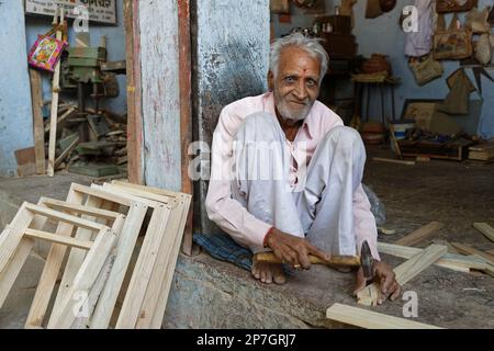 LAKHERI, INDE, 7 novembre 2017 : un vieil homme indien travaille sur des pièces de bois pour fabriquer des cadres. Banque D'Images